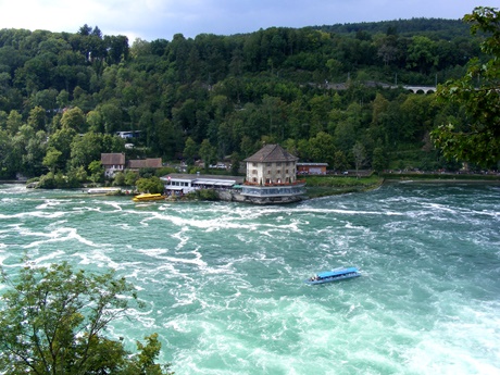 Ein blaues Rundfahrt-Boot beim unterhalb des Rheinfalls gelegenen Schlössli Wörth.