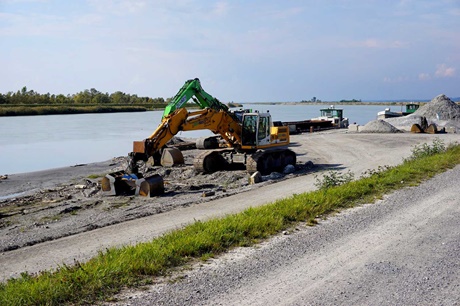 Ein Kiesbagger entfernt vom Rhein mitgeschwemmtes Geröll.