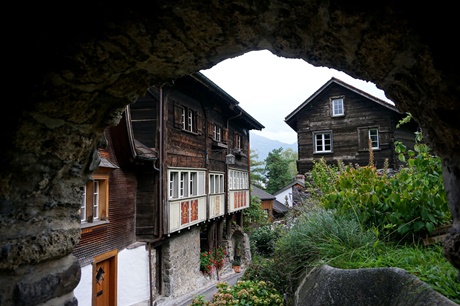 Romantischer "Torbogen-Blick" auf zwei Holzhäuser in Werdenberg.