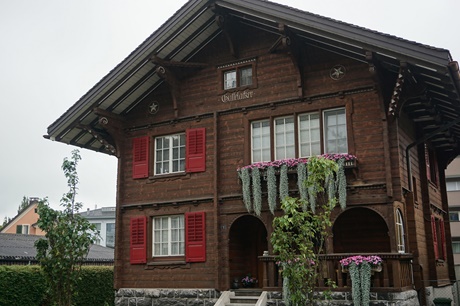 Prächtiges Holzhaus mit schönen Verzierungen und originellem Blumenschmuck.