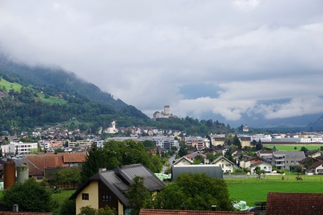 Blick auf das von wolkenverhangenen Bergen umgebene Sargans - in der Bildmitte das majestätische Schloss.