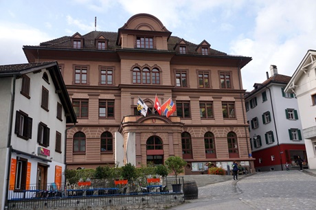 Das mit Kantons-, Landes- und Stadtflagge geschmückte Rathaus von Ilanz.