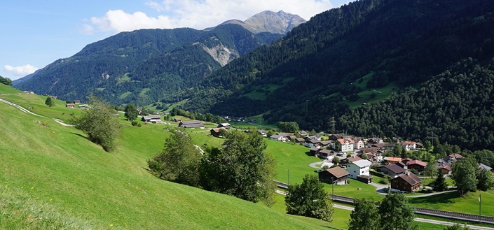 Die von Weiden und bewaldeten Berghängen geprägte Surselva (bei Disentis).