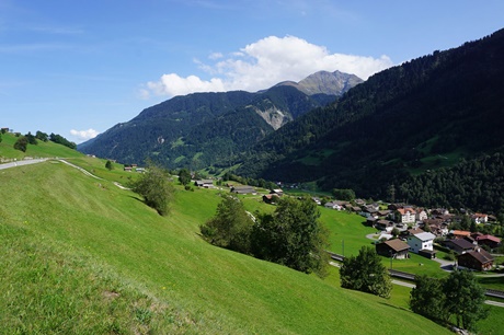 Die Obere Surselva bei Disentis mit ihren typischen sattgrünen Weiden und üppig bewaldeten Berghängen.