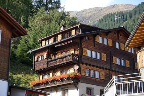 Ein typisches, schön mit Blumen geschmücktes Holzchalet in Disentis.