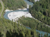 Der türkisgrüne Rhein windet sich in der Rheinschlucht an sattgrünen Nadelwäldern vorbei.